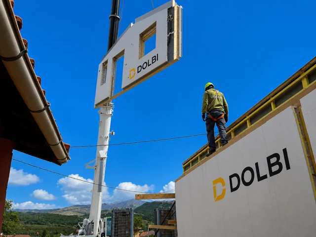 Grúa elevando un panel DOLBI con hueco de ventana durante el montaje